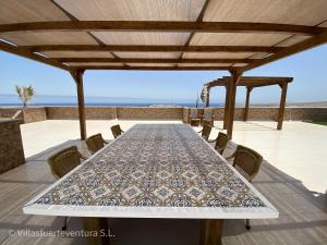 einen Tisch und Stühle auf einer Terrasse mit Meerblick in der Unterkunft Edificio Prieto VIV 5 in Puerto del Rosario