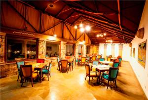 un restaurante con mesas y sillas en una habitación en The Earth at Ranthambore, en Sawāi Mādhopur