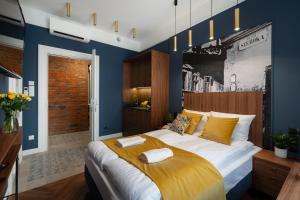 sypialnia z dużym łóżkiem z żółtymi i niebieskimi ścianami w obiekcie Starowislna 77 w Krakowie