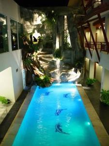 una piscina en una casa con cascada en V Verve Service Apartment Hotel en Chachoengsao
