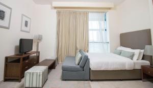 a hotel room with a bed and a television at Spacious Studio - Sports city - Diamond in Dubai