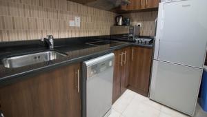 a kitchen with a sink and a white refrigerator at Spacious Studio - Sports city - Diamond in Dubai