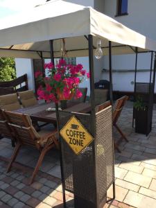 a coffee zone sign in front of a table with flowers at Cerla Korbielów 16 Plus in Korbielów