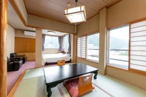 una camera con tavolo, letto e finestre di Itoen Hotel New Sakura a Nikko