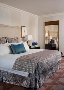 a bedroom with a large bed and a mirror at Lotte New York Palace in New York