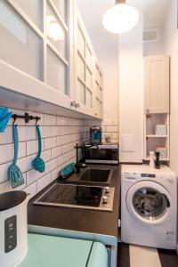 a kitchen with a sink and a washing machine at Apartamenty Wójcik Loft in Gdynia