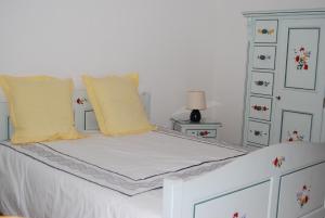 Chambre d'hôtes Kieffer Le Grand Bienfaisy في رميريمو: سرير أبيض مع وسائد صفراء وخزانة بيضاء
