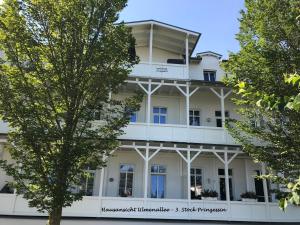 a white building with trees in front of it at Meerblick Apartments Villa Vineta Göhren in Göhren