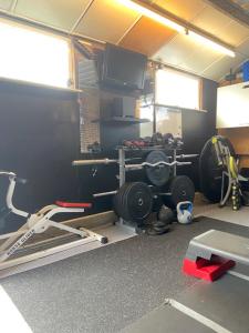 a room with a gym with a television and weights at Characteristic detached house next to water in Zaandam