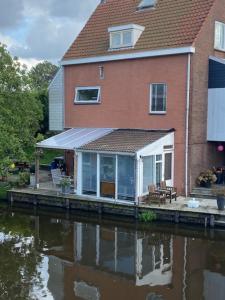 a house with a dock next to a body of water at Characteristic detached house next to water in Zaandam