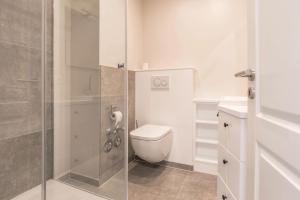 a bathroom with a toilet and a glass shower at Strandburg in Westerland (Sylt) +17 photos