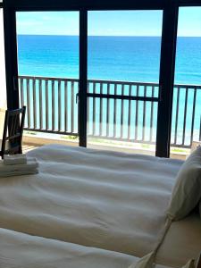 a bedroom with a bed and a view of the ocean at Guesthouse High Wave in Yanliau