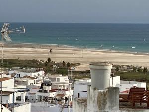 コニル・デ・ラ・フロンテーラにあるPiso en Conil con Vistas al marの白い建物と海の景色を望むビーチの景色
