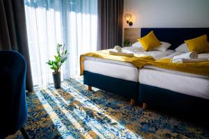 a hotel room with two beds and a window at Plaża Resort Łeba in Łeba