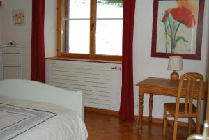een slaapkamer met een bed, een bureau en een raam bij Chambre d'hôtes Kieffer Le Grand Bienfaisy in Remiremont