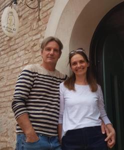 Un uomo e una donna in piedi davanti a un palazzo di Cà Tabachera a Rimini