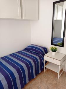 a bedroom with a bed and a table and a mirror at Mafasca, comodo e silenzioso, terrazza e cortile, WI-Fi in Morro del Jable