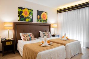 Giường trong phòng chung tại Hotel Jardim