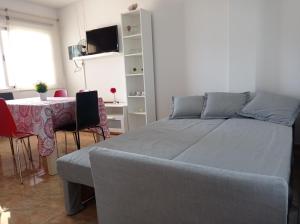 a bedroom with a bed and a table and a table and chairs at Mafasca, comodo e silenzioso, terrazza e cortile, WI-Fi in Morro del Jable