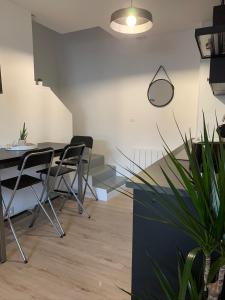 a room with a table and chairs and a potted plant at Logement rénové et moderne au Sacré Coeur Cholet in Cholet +10 photos