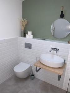 a bathroom with a sink and a toilet and a mirror at Logement rénové et moderne au Sacré Coeur Cholet in Cholet