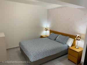 um quarto com uma cama e 2 candeeiros nas mesas em Edificio Prieto VIV 6 em Puerto del Rosario
