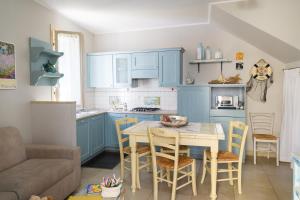 a kitchen with blue cabinets and a table and chairs at Cà Tabachera in Rimini