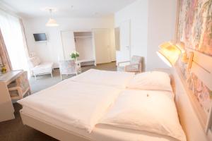 Schlafzimmer mit einem großen weißen Bett und einem Schreibtisch in der Unterkunft Hotel Heidenauer Hof in Heidenau