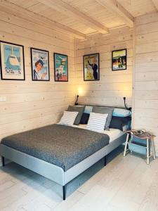 ein Schlafzimmer mit einem Bett in einem Holzzimmer in der Unterkunft Sunny Corner Holiday Apartment in Rheinböllen