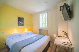 a bedroom with a large bed and a television at Residence Metropole Toulouse in Toulouse