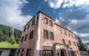 ein großes Backsteingebäude vor einem Berg in der Unterkunft Hotel Alte Post by Mountain Hotels in Davos