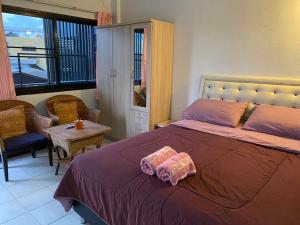 een slaapkamer met een bed, een tafel en een raam bij Ban Pongphan in Chiang Mai