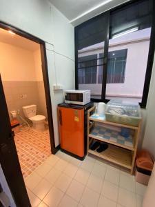 a room with a kitchen with a microwave on a refrigerator at Ban Pongphan in Chiang Mai