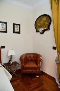 ein Zimmer mit einem Stuhl und einer Uhr an der Wand in der Unterkunft Regal House Roma in Rom