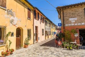 una calle en un casco antiguo con edificios y mesas en Cà Tabachera, en Rímini