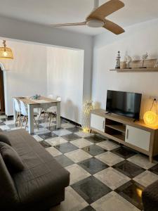 a living room with a couch and a tv and a table at Piso en Conil con Vistas al mar in Conil de la Frontera