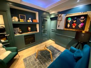 a living room with blue walls and a fireplace at Hôtel Etoile Trocadéro in Paris +38 photos