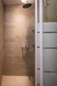 a shower with a glass door in a bathroom at Omirou “Best Kept Secret” in Athens