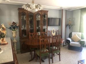 a dining room with a table and a china cabinet at ALOJAMIENTO LA EXPLANADA in Pegalajar