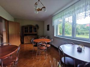 a dining room with tables and chairs and a window at Noclegi "Na Szczyrboku" Dom II in Korbielów