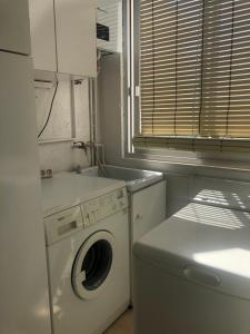 uma lavandaria com uma máquina de lavar roupa e uma janela em ALOJAMIENTO LA EXPLANADA em Pegalajar