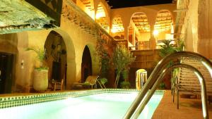 a large swimming pool in a building with a swimming pooliterator at Riad Maktoub in Aït Benhaddou