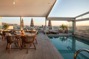 ein Restaurant mit Pool auf dem Dach eines Gebäudes in der Unterkunft Green Suites Boutique Hotel in Athen