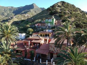 un grupo de casas en una colina con palmeras en Casas Rurales Pie de la Cuesta1, en Vallehermoso