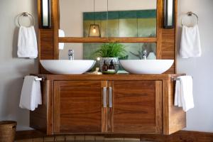 a bathroom with two sinks on a wooden cabinet at Simbavati Camp George in Klaserie Private Nature Reserve