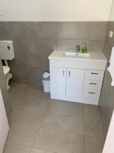 a bathroom with a white sink and a toilet at Mount Beauty Motor Inn in Mount Beauty