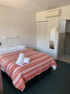 a hotel room with a bed with two towels on it at Mount Beauty Motor Inn in Mount Beauty