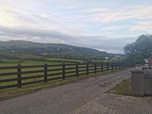a wooden fence on the side of a road at Neds Brae View in the Glens of Antrim Family and Pet friendly Carnlough home in Carnlough
