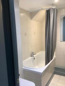 a bathroom with a bath tub with a shower curtain at The Mooring Post in Gloucester