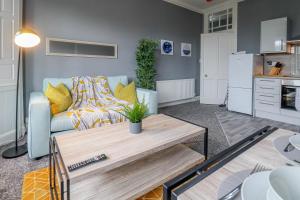 un soggiorno con divano e tavolo di Cosy Seaside Princes Apartment a Helensburgh